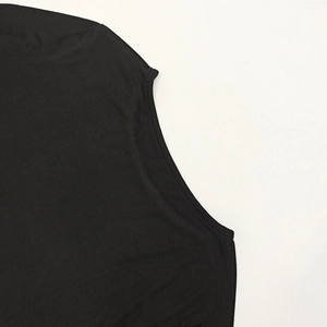 Detail view of double-stitched seams on shoulder of black slim fit cotton knit top