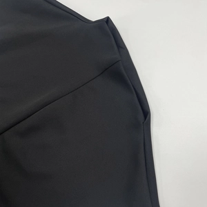 Close-up of flat side seams and invisible pocket detail on black A-line dress fabric