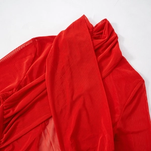 Detail of red mesh dress showing criss-cross pleats and sheer textured fabric