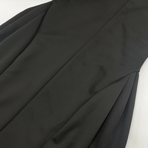 Detail shot of the black dress fabric showing premium stitching and smooth texture