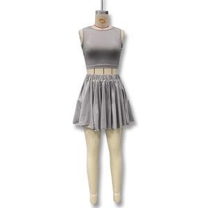 Detail view of the light grey ribbed knit crop top and high-waisted pleated mini skirt set
