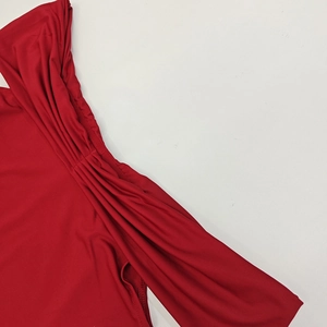 Gros plan des détails froncés et des coutures fines sur le tissu d'une robe rouge