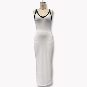 Détail d'une robe longue blanche ajustée avec col en V et liseré noir contrastant