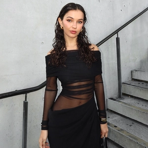 Detail view of the black off-shoulder dress featuring sheer mesh ruching and stitching