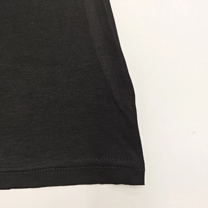 Close-up of double-needle stitching and fine knit texture on a black slim top