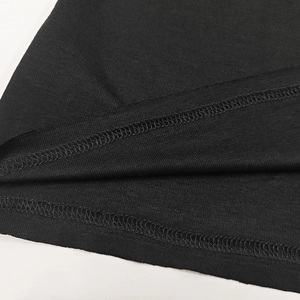 Detail of high-density double-needle stitching on black knit slim long sleeve top hem