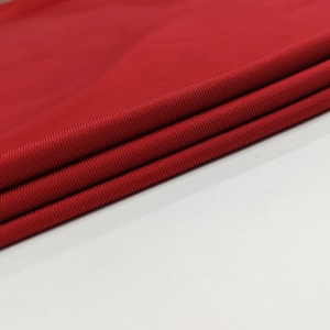 Gros plan du tissu en maille rouge montrant la texture premium et la densite de la robe