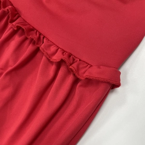 Détail du haut en tricot rouge avec couture à volants texturée et ourlet plissé élégant