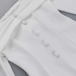 Detail of off-shoulder fold neckline with five white fabric-covered buttons on the dress