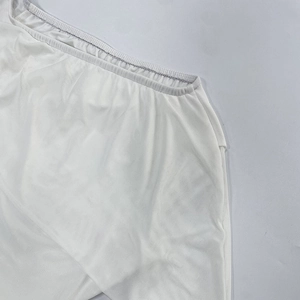 Détail du tissu en maille blanche avec taille élastique plissée et couture soignée