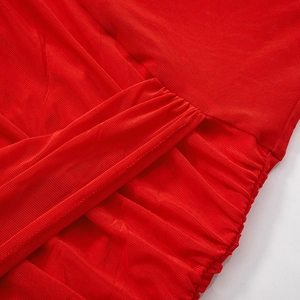 Close-up of red mesh fabric showing detailed ruching and pleated texture on the dress