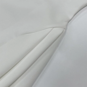 Detailed close-up of white dress fabric showing high-quality stitching and pleated texture