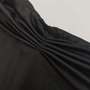 Détail de tissu froncé noir montrant la texture plissée et la qualité de la matière