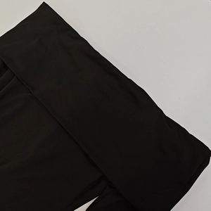 Detail shot of black knitted off-shoulder dress showing soft elastic fabric texture