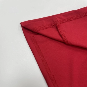 Vue macro des coutures surjetées précises et des détails du tissu en maille rouge