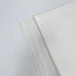 Détail de la robe en maille blanche montrant la couture plate et le tissu à texture fine