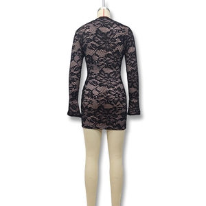 Dettaglio del pizzo floreale nero con fodera color carne sul vestito a maniche lunghe