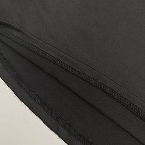 Gros plan détaillé des coutures overlock et de l'ourlet à double aiguille sur tissu noir