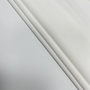 Détail macro de la texture du tissu en maille blanche et du tissage serré de la robe