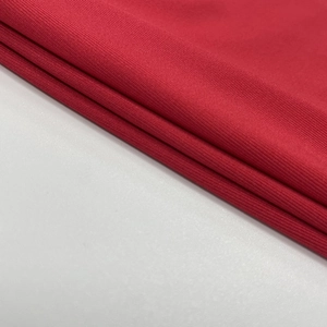 Gros plan détaillé de la texture du tissu tricoté rouge avec motif à fines côtes