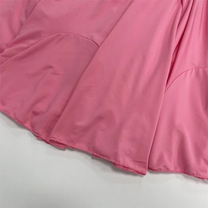 Close-up of pink fabric detail with professional overlock stitching on the hemline