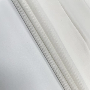 Vue macro du tissu en maille blanche montrant la texture détaillée de la robe en tulle