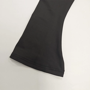 Detail of black knit sleeve with double-needle stitching and flared cuff design