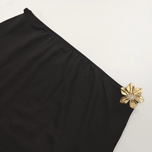 Detail of black knit fabric with exquisite gold flower ornament and crystal inlay