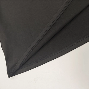 Detailed close-up showing professional double-needle stitching on black knit fabric hem