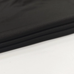 Detail shot of black knitted fabric with fine grid texture and soft pleated layers