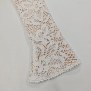 Dettaglio della manica a campana in pizzo floreale con fodera beige e ricami eleganti
