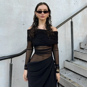 Detail view of the sheer mesh patchwork and ruched design on the black off-shoulder dress