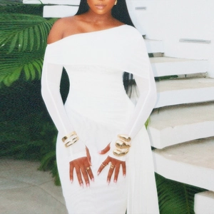 Détail de robe blanche moulante à épaules dénudées avec poignets à passe-pouce et tulle