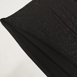 Detailed macro view of black glitter fabric with high-quality edge stitching and inner lining