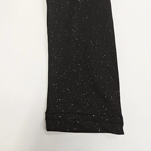 Detail of black dress fabric with shimmering silver sequins and double-needle stitching