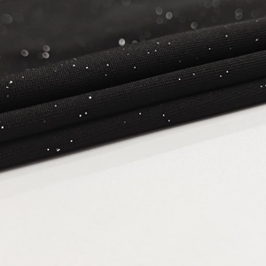 Detailed macro view of black knit fabric with silver glitter and soft texture