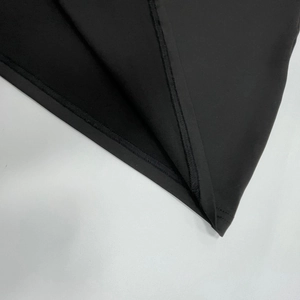 Détail de la couture et de la finition de l'ourlet sur la robe moulante noire chic