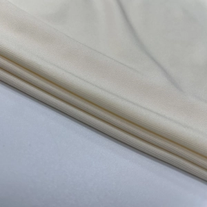 Gros plan détaillé sur la texture du tricot crème et les coutures de qualité sur la jupe