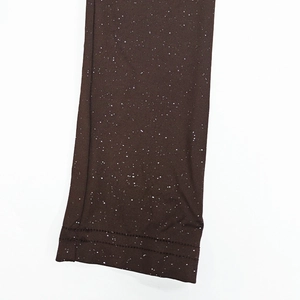 Macro detail of dark brown ruched fabric with white star-like dots and double stitching