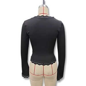 Close-up of elegant black slim fit top with delicate lace trim on hem and cuffs