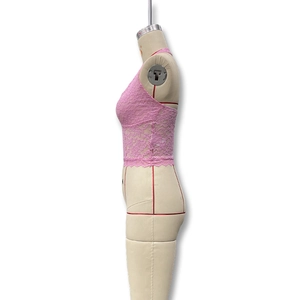 Détail d'un haut licou en dentelle florale rose avec bords festonnés sur mannequin de couture