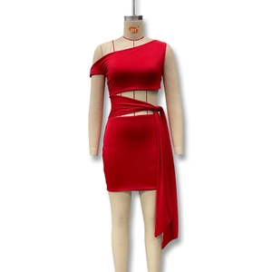 Detail of red one-shoulder dress featuring waist cut-out and long decorative ribbons