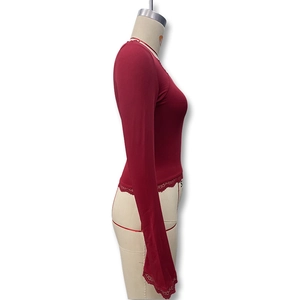 Detail of dark red slim fit knit top featuring delicate lace trim on cuffs and hemline