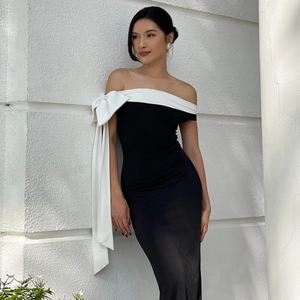 Robe moulante élégante avec épaules dénudées et grand nœud blanc pour un style raffiné