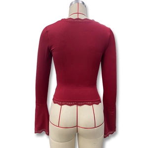 Close-up of dark red slim-fit top with delicate lace trim and flared bell sleeves back