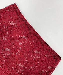 Detail of dark red rose lace fabric with hollow out floral patterns and embroidery texture