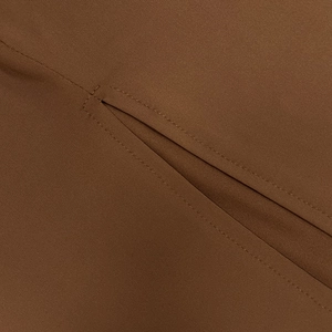 Détail d'une robe marron à capuche montrant les coutures et la fente à l'arrière