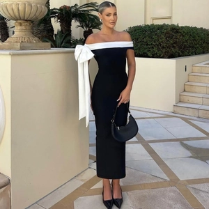 Détail de la robe mi-longue noire à épaules dénudées avec un grand nœud blanc chic