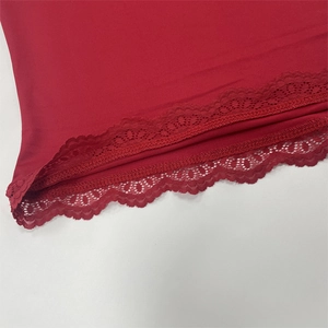 Detailed macro view of dark red top hem featuring delicate scalloped lace edge trim