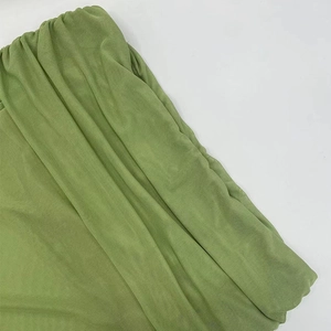 Detailed close-up of avocado green pleated mesh fabric with elegant ruffled texture